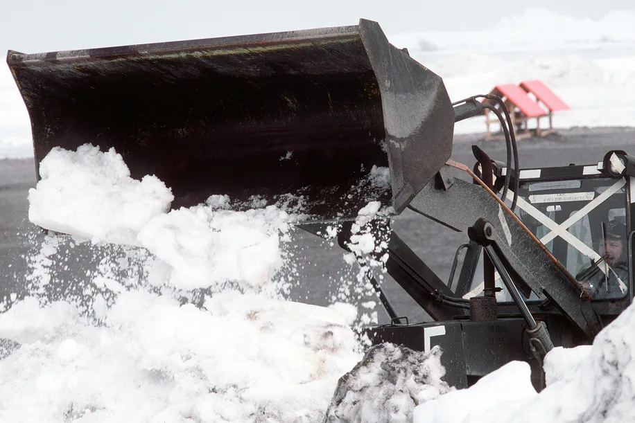 A contractor removes snow with a plow