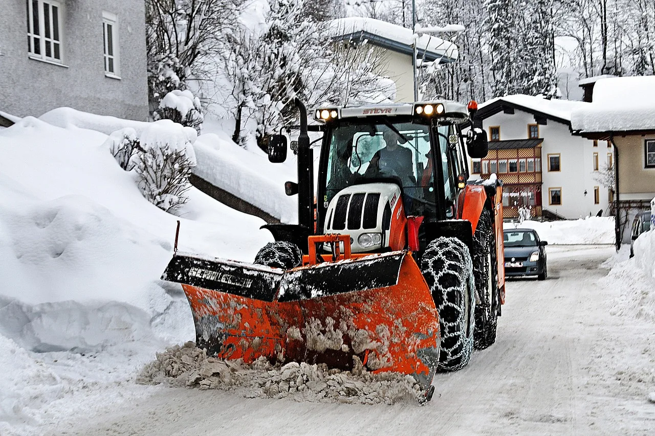 snow plow clearing snow from residential street